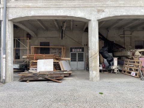 Kunstobjekt aus einer Plastikfigur eines Pferdes in einer Umgebung aus Beton und Holz.